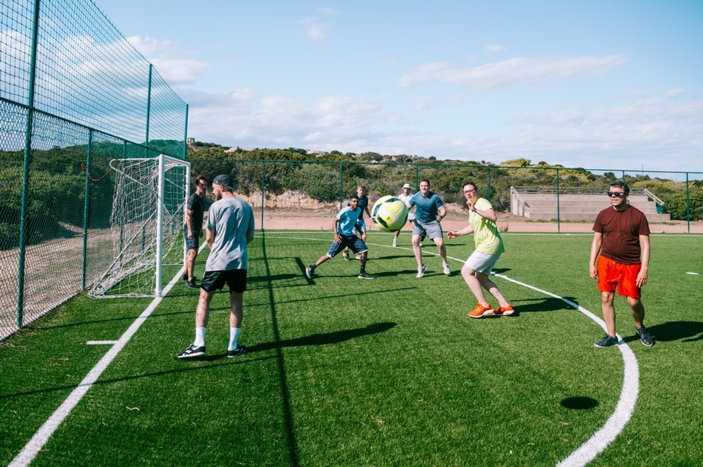 Group playing football all around the goalpost
