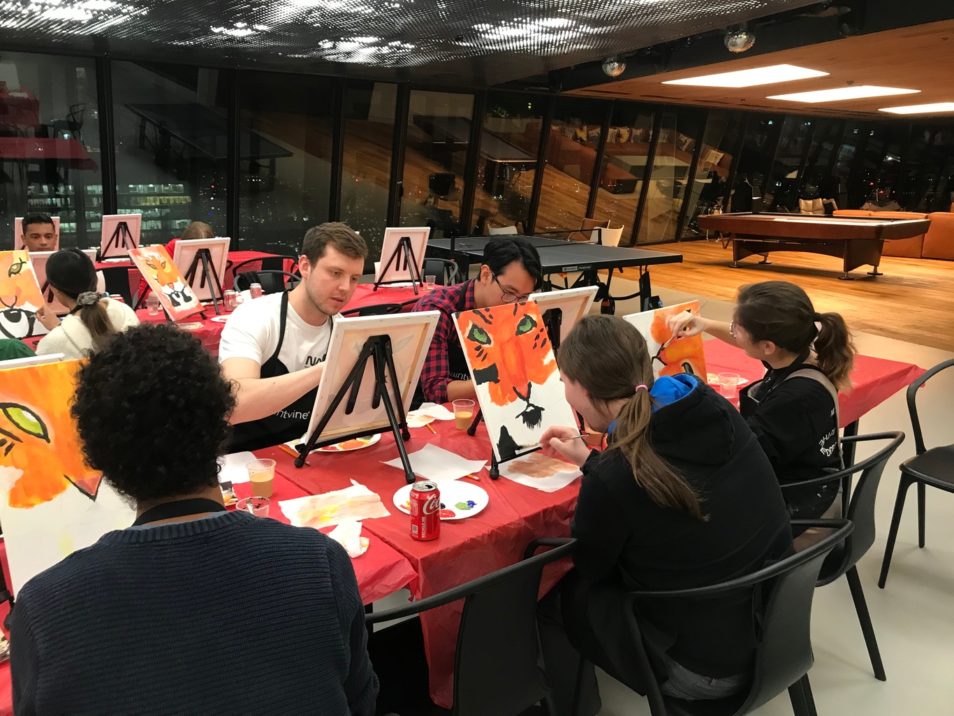 People in the breakout space painting on individual canvases